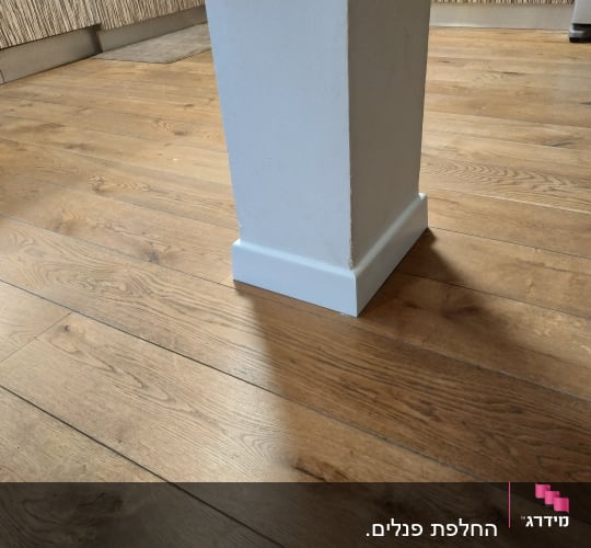רצפת פרקט עץ עם עמוד לבן במרכז